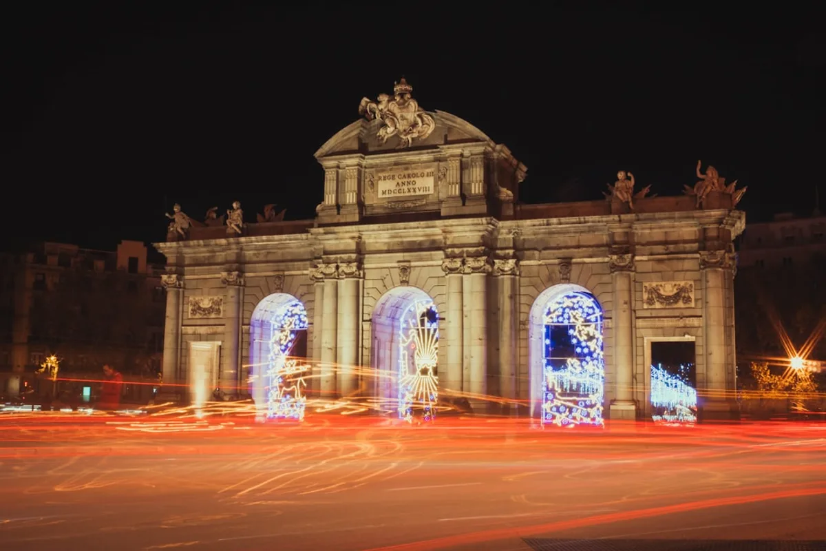 Puerta de Alcalá neoclassical gate illuminated at dusk in Madrid