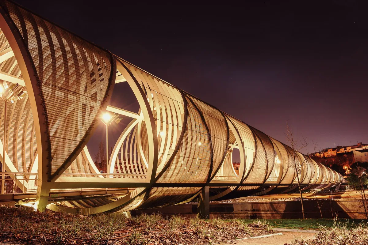 The illuminated Puente de Arganzuela, a spiral pedestrian bridge over the Manzanares river, at night