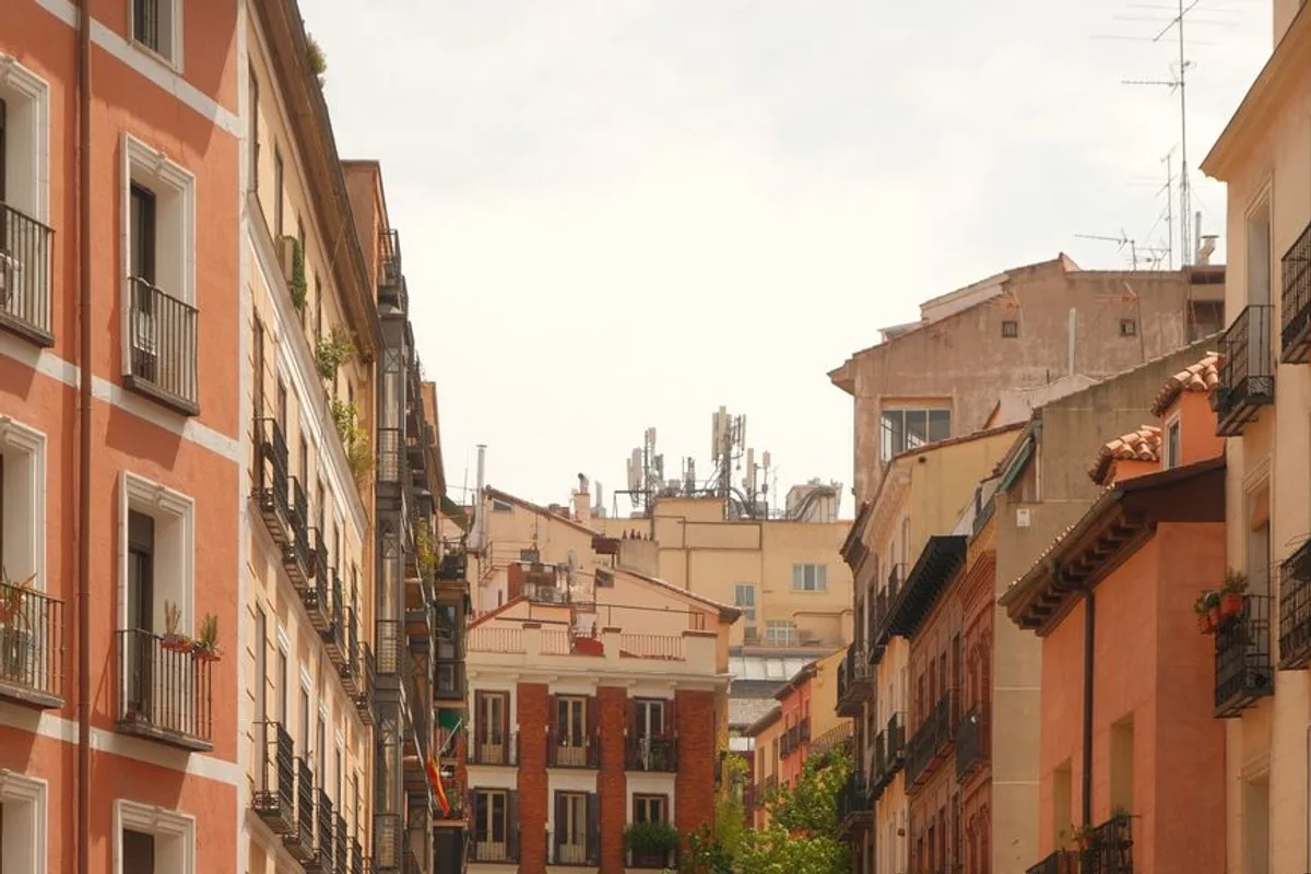 A narrow street of terracotta-toned traditional buildings in Lavapiés, Madrid